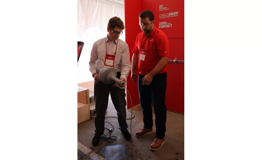 BNP Media Plumbing Group Publisher Bob Miodonski receives a hands-on demonstration of drain-cleaning products