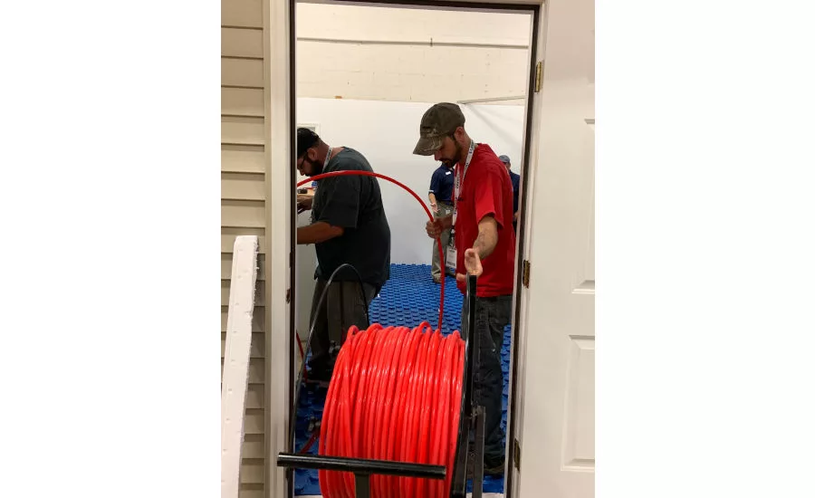 Attendees install radiant tubing in the VersaTherm