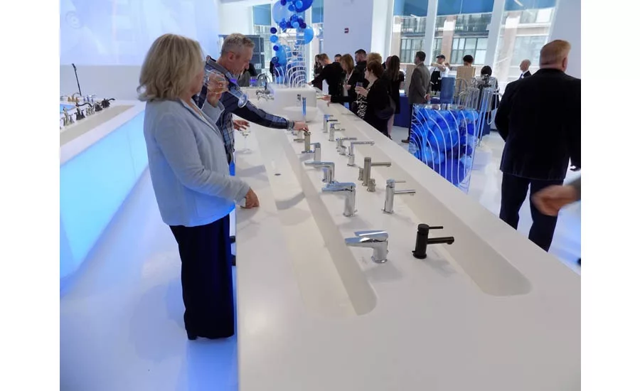 Guests at the grand opening event try out some more of Moen