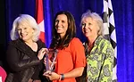 Angie Snow (center), owner and vice president of Western Heating and Air Conditioning in Boise, Idaho, receives the inaugural Woman of the Year award during Service World Expo in Las Vegas
