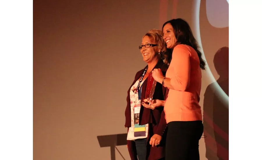 Angie Snow presents the 2017 Woman of the Year award to Amy Davis (left), vice president of Budget Plumbing, Heating and Cooling in St. Peters, Mo., at the 2017 Service World Expo in Las Vegas