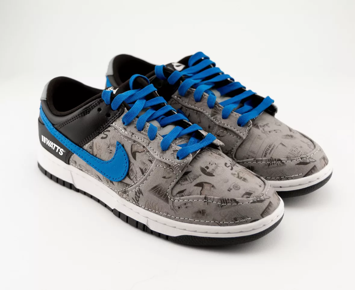 The Watts themed Nike dunks, gray with blue shoelaces. 