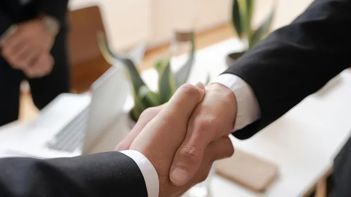 Airo Mechanical Adds Legrande’s Enterprises to Its Growing Business Two people shaking hands.
