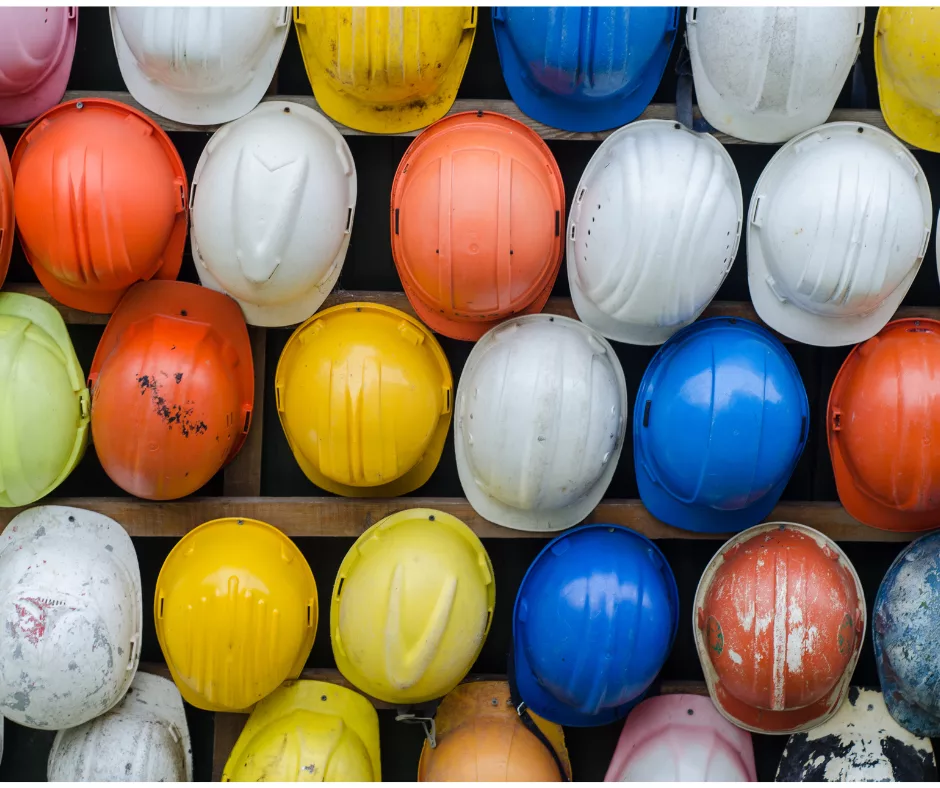 Hardhats of several different colors, lined up together. 