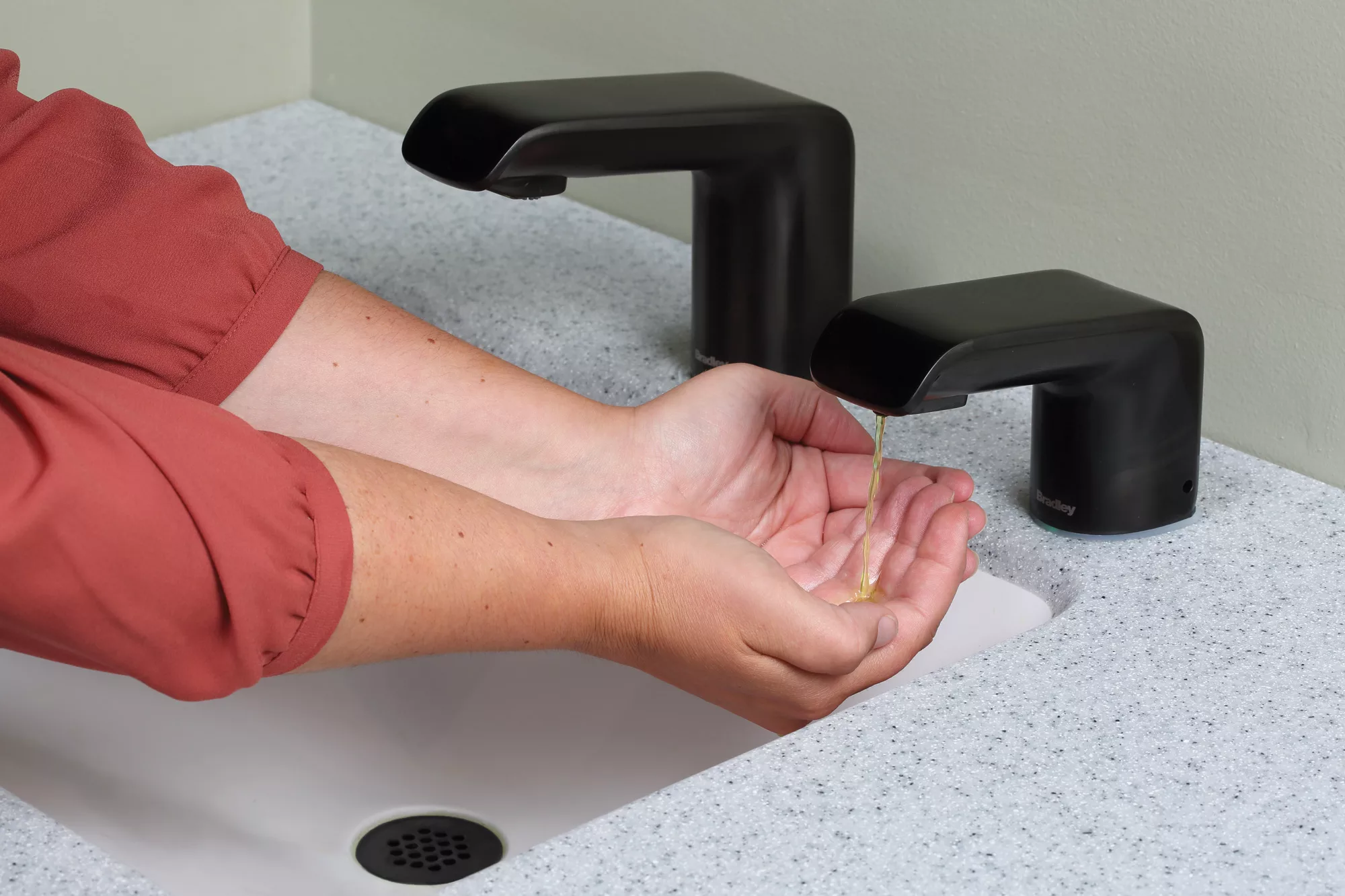 A person using an automatic soap dispenser. 