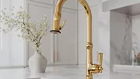 Newport Brass Jacobean pull down kitchen faucets A gold kitchen faucet by Newport Brass in a white kitchen.