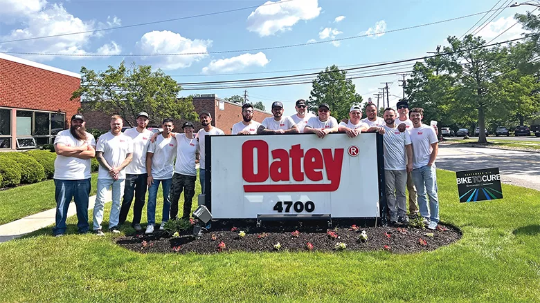 Several influencers standing around the Oatey Co. sign at Ambassador Fest.