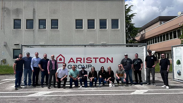 The contractors on the trip posing in front of a sign for the Ariston Group.