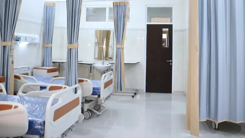 A hospital room with several beds. 