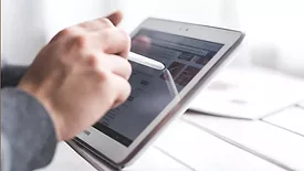 A person using a tablet and smart pen. 