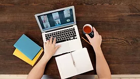 A person attending a virtual class on a computer. 