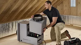 A person installing the Honeywell Home Whole House Dehumidifier. 