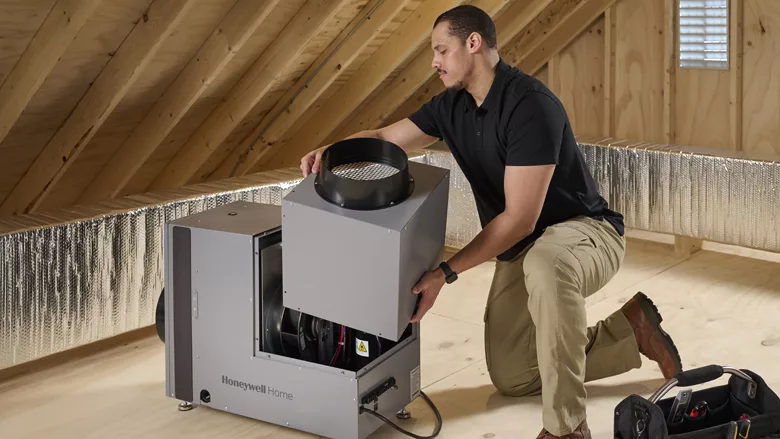 A person installing the Honeywell Home Whole House Dehumidifier. 