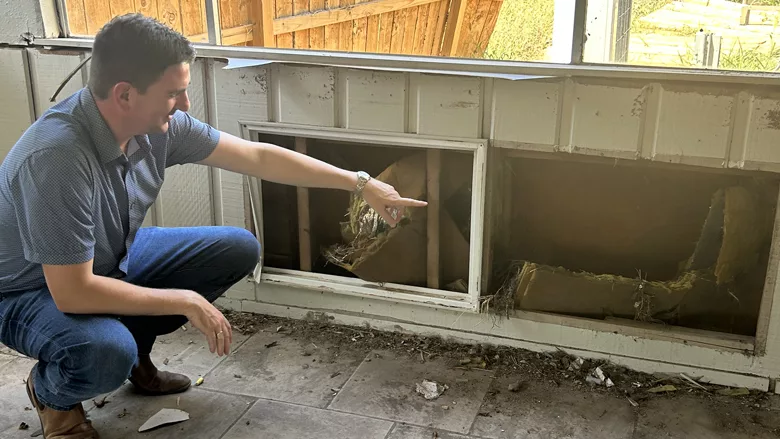 Austin Dickson inspects damage at a local arts nonprofit organization after floods ripped through the arts center in Ingram Texas