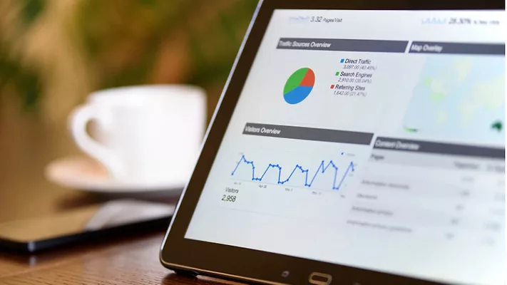 A person using a tablet with charts on it. 