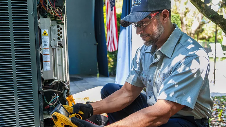 An HVAC technician working on an air conditioning unit.
