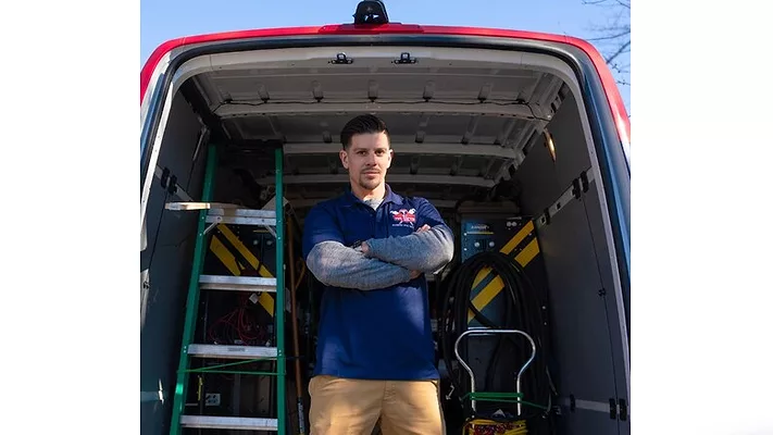 A worker standing in front of a van.