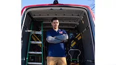 A worker standing in front of a van.