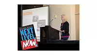 Heather Ripley launches updated “Next Level Now” book for home services Heather Ripley addressing a crowd, with her book "Next Level Now."