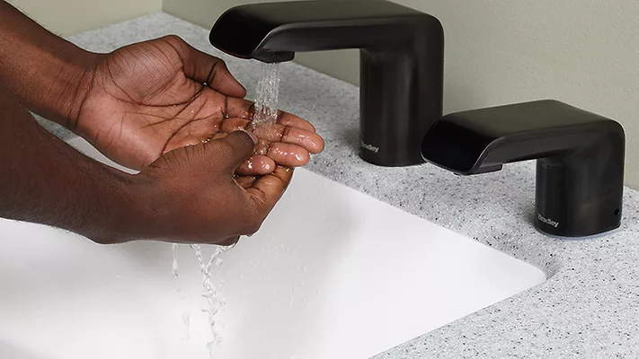 A person washing their hands. 