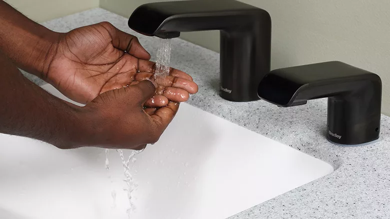 A person washing their hands. 