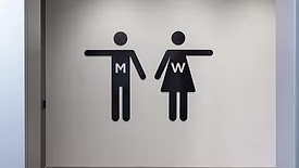 Two signs pointing to restrooms.
