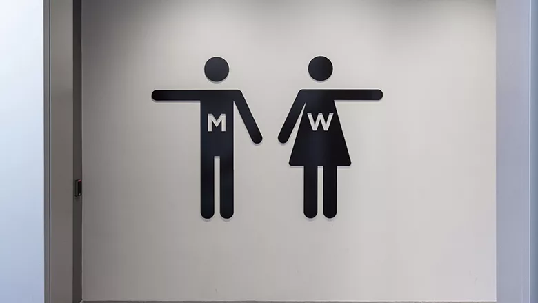 Two signs pointing to restrooms.