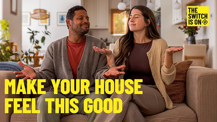 Two home-owners sitting on a couch, with "Make your house feel this good" and "The switch is on" written above them.