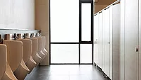 A commercial bathroom with several urinals.