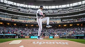 A baseball player preparing a pitch with "Uponor" written on the pitcher's mound. 
