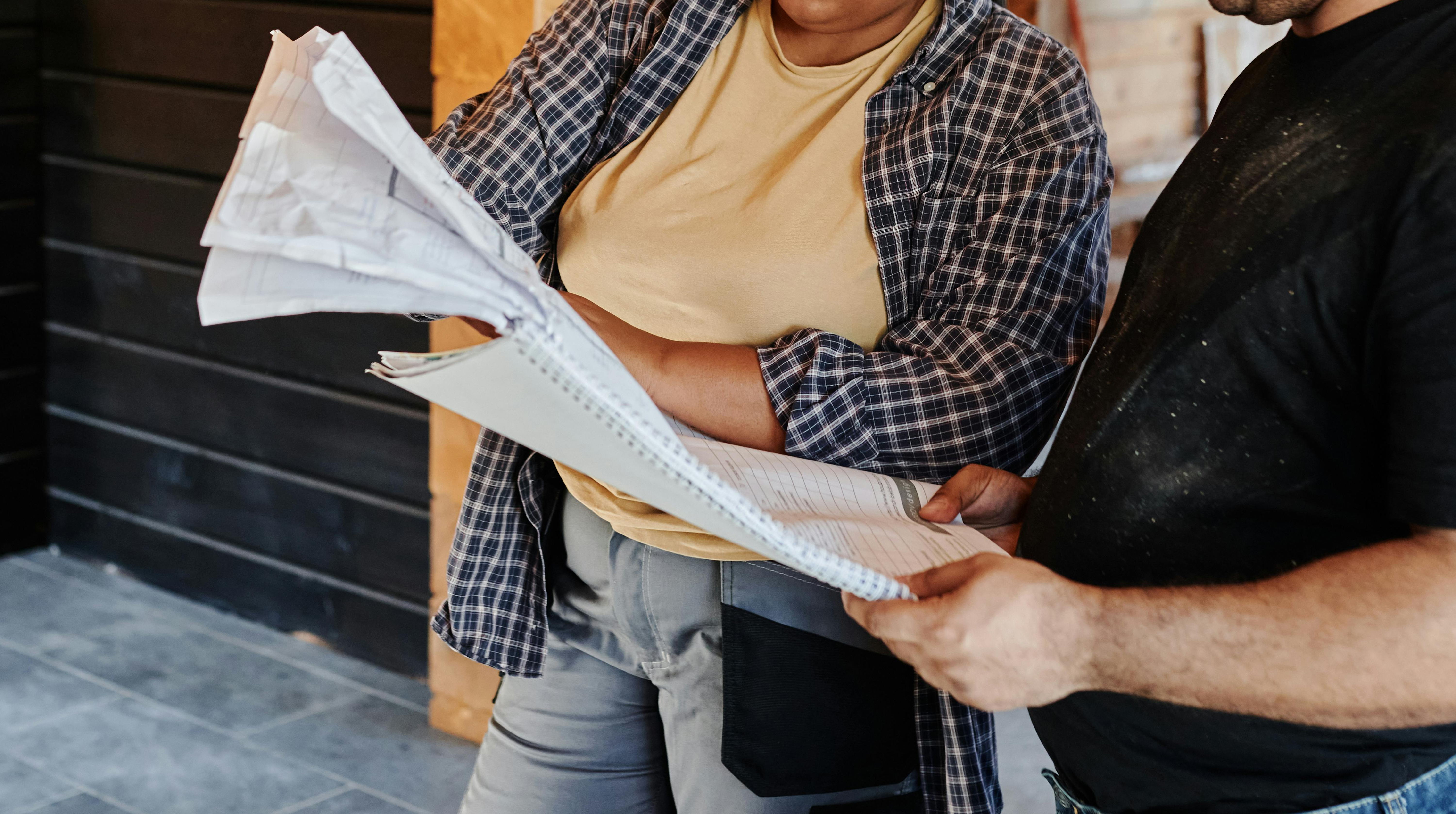 Two contractors looking at documents. 