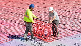Field installation of RAUMAT showcasing fast-roll placement of pre-assembled radiant circuits