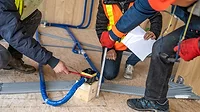Three Plumbers Discuss Job with Blueprints Three Plumbers Discuss Job with Blueprints