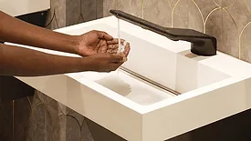 A person washing their hands. 