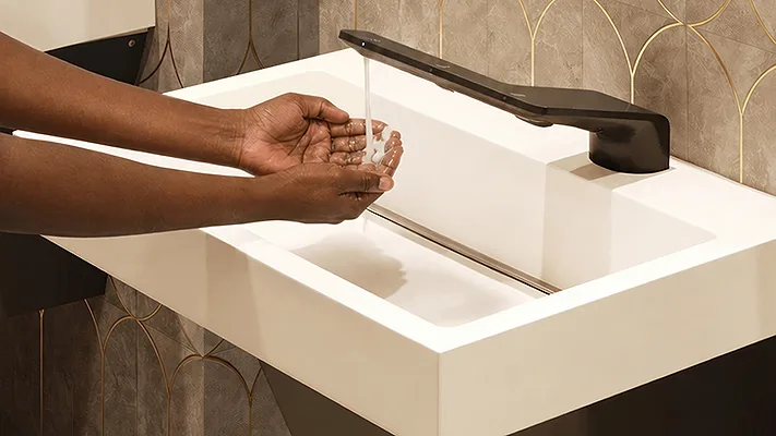 A person washing their hands. 