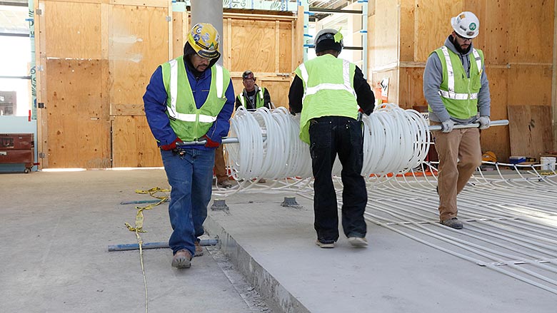 Contractors complete a radiant floor heating installation 