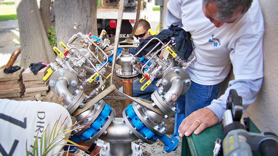 Technicians install a twin arrangement of backflow assemblies 