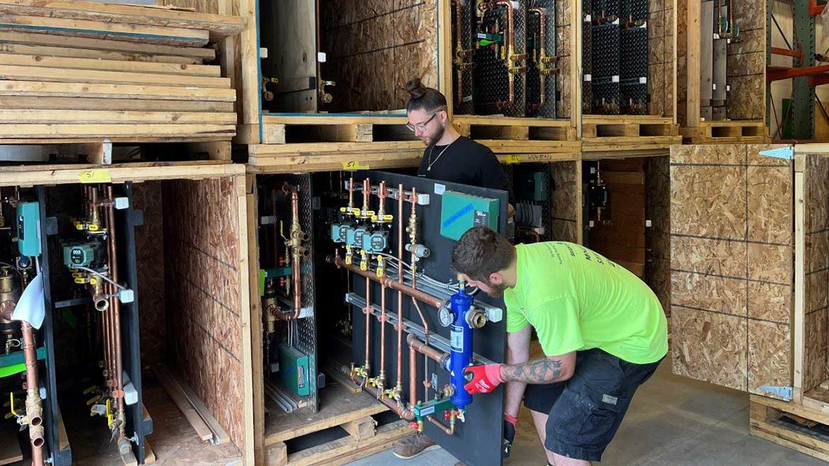 02 PM 1223 FW Webb feature. F.W. Webb Warehouse Manager Mike DiPirro (foreground) and Shipping Supervisor Matt Souza (standing), prepare preassembled hydronic panels for shipment.