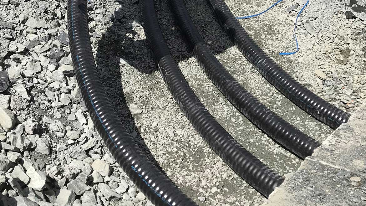 Four REHAU INSULPEX piping in the ground, surrounded by gravel and cement at the Vancouver Island Schools.