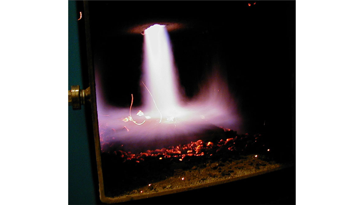 Figure 3 shows the injection of secondary air into the gases from holes within the plate causing intense combustion.