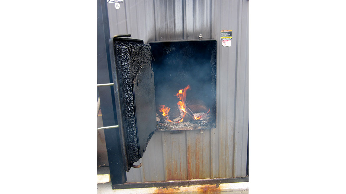 April John Siegenthaler column, Figure 4 is an example of how creosote can coat the combustion chamber surfaces of outdoor wood-fired hydronic heaters.