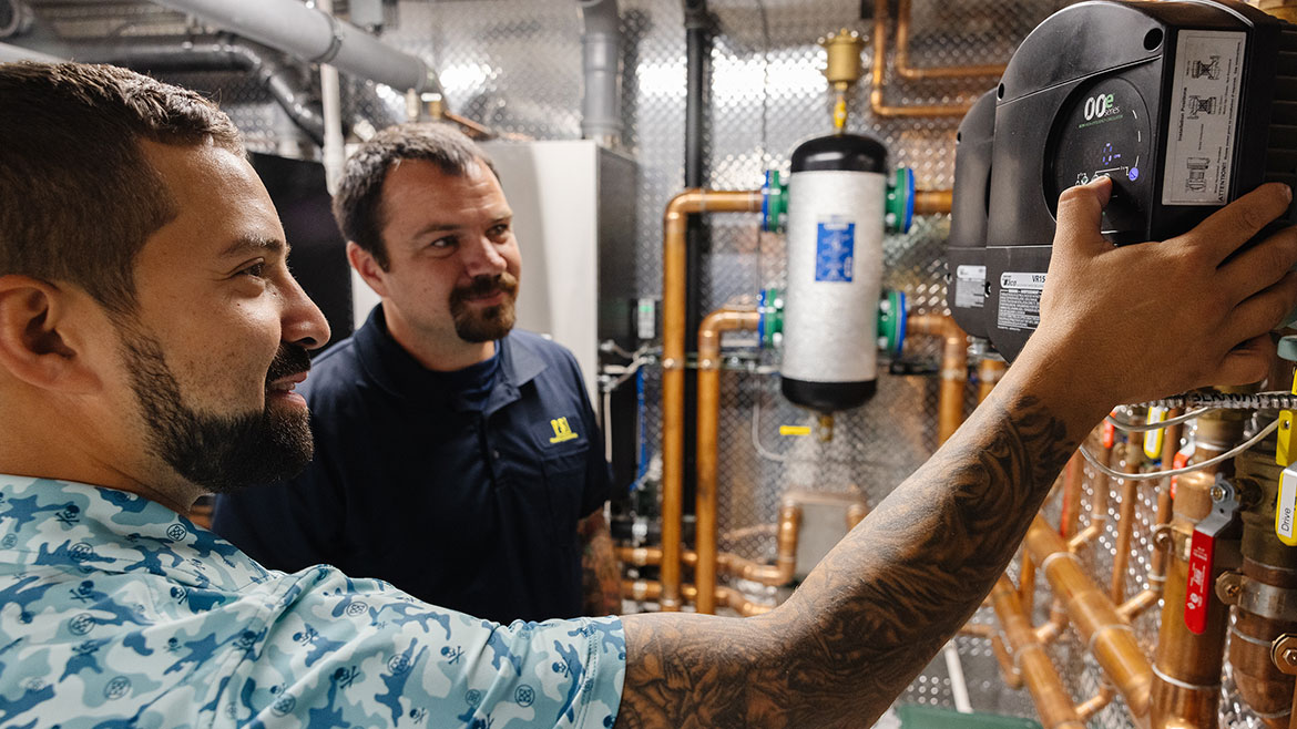 Brandon Content explains the snow-melt system’s operation to the property caretaker.