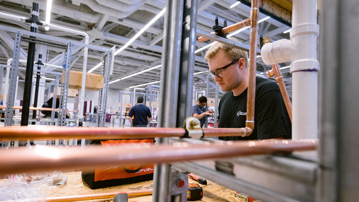 Apprentice working on pipes.