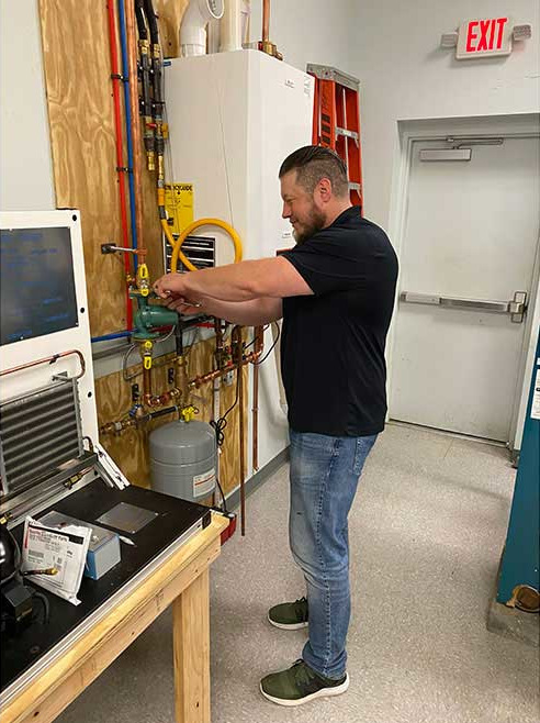 Ben Farber, a student at PPATEC, is working on an installation in the classroom.