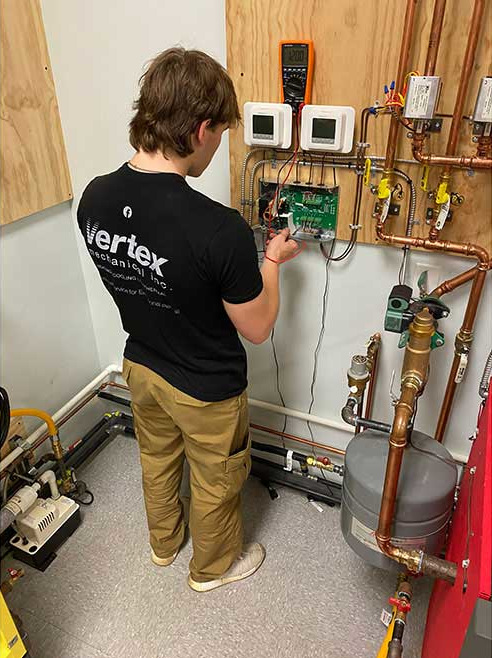Student, Alex Kreider is standing in a lab, working on a project at PPATEC.