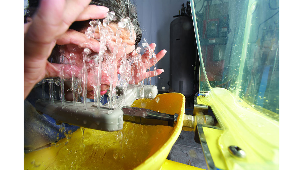 Close-up of worker using an eye and face emergency wash model