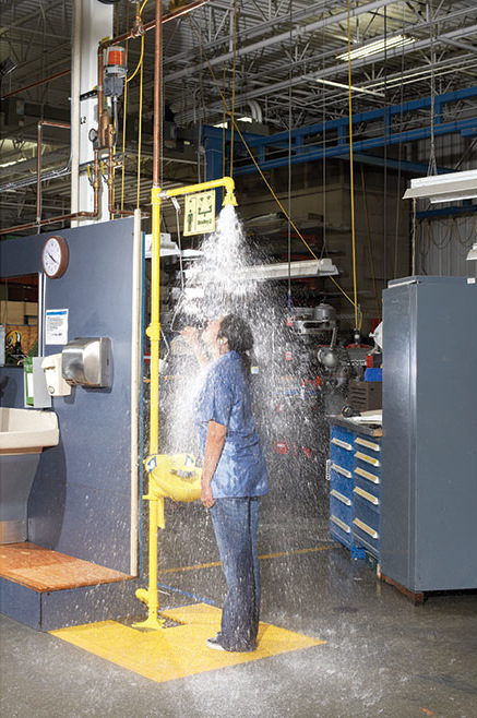 Female worker using a drench shower.