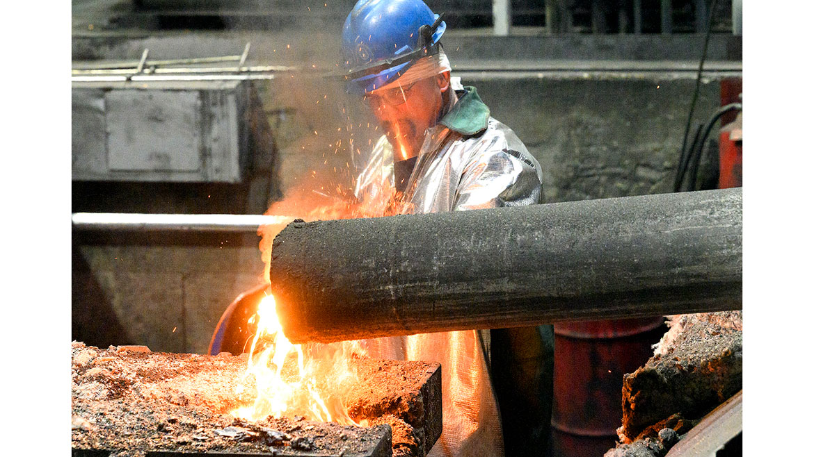 NIBCO Stuarts Draft Plant photo of worker in safety headgear and protective jacket working in extreme heat.