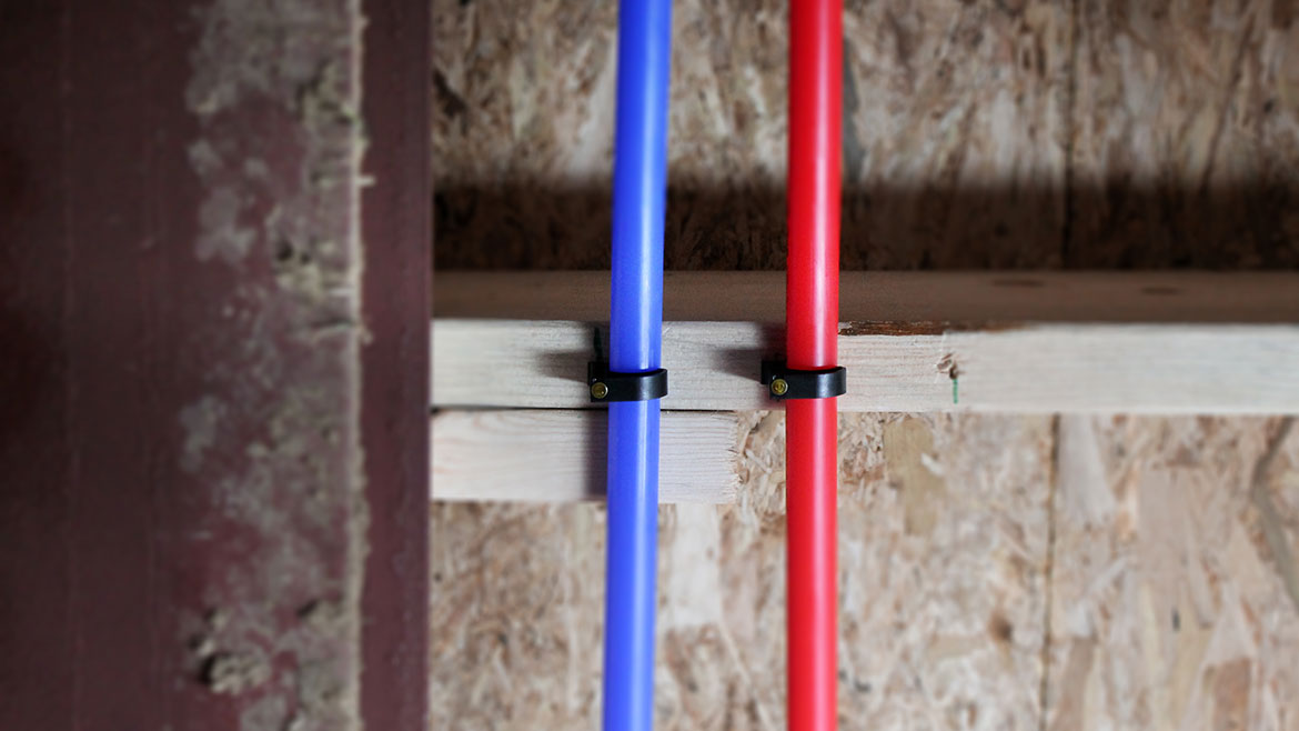 Blue and red water pipes secured with straps.