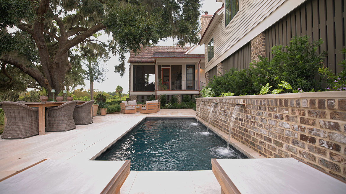 Pool with waterfalls and an outdoor patio.